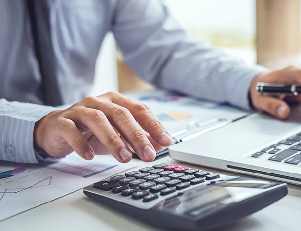 パソコンと電卓を使う人の写真
